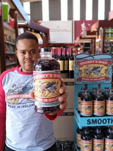 A man holding up a bottle of jambalaya in a store during Jr promotions.