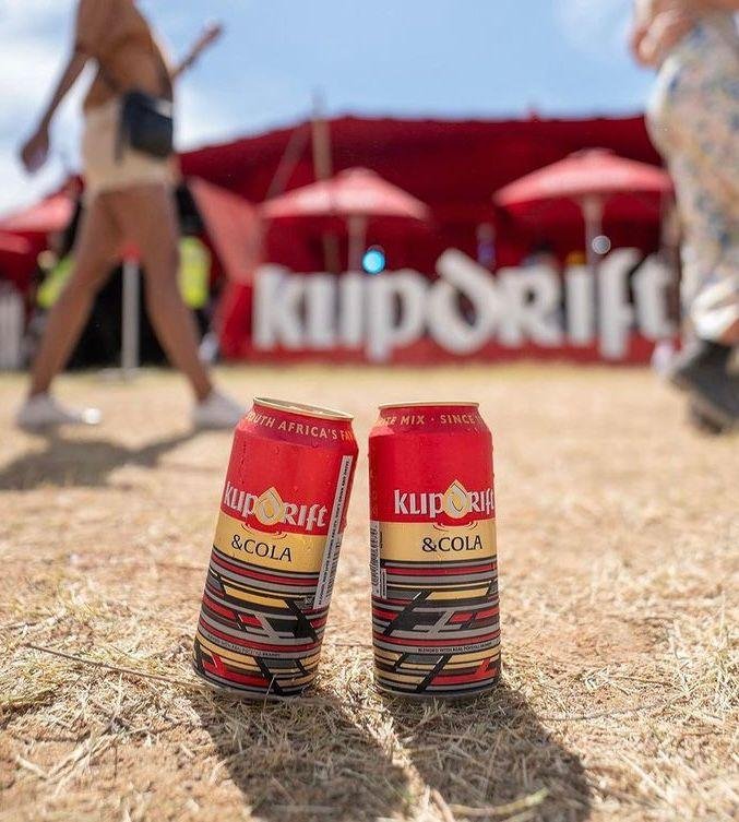 Two cans of beer sitting on a grassy field at Rocking the Daisies.