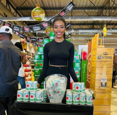 A woman standing in front of a Heineken Silver display.