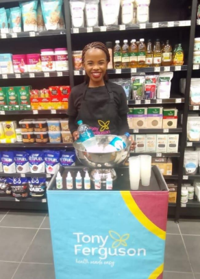 A woman standing in front of a display of products.